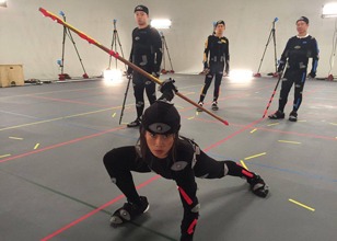 Stunt performers in motion capture suits posing with weapons in a studio, utilizing taekwondo techniques for high-end digital reelstunt sequences.